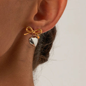 Ατσάλινα σκουλαρίκια καρφάκι, φιογκος με κρεμαστή καρδιά, σε κίτρινο χρυσό & ασημί 01032411